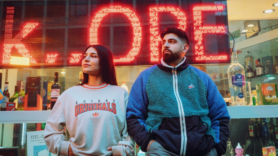 Meltem und Yousuf von Chai Society stehen vor einem Kiosk.