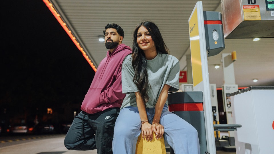 Meltem und Yousuf bei einer Tankstelle. 